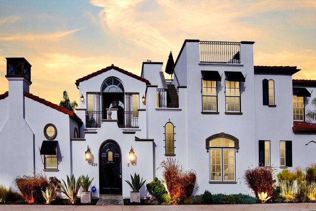 Spanish-style home at sunset with outdoor lighting