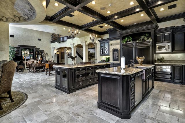Chef's kitchen with dark cabinetry and coffered ceiling