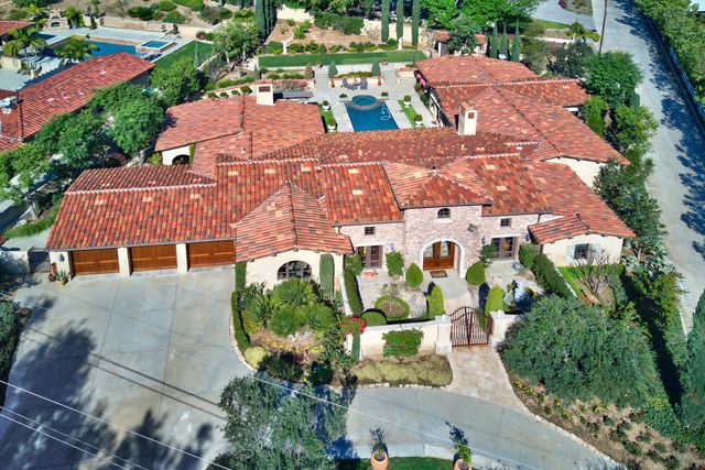 Aerial view of a Mediterranean villa with red tile roof and pool