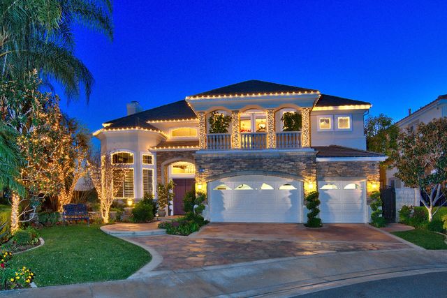 Two-story home with holiday lights at twilight
