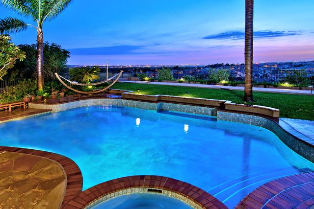 Pool and spa overlooking the city at dusk