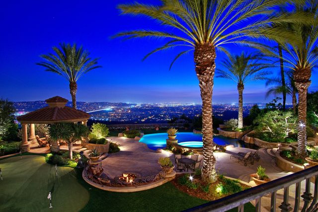 Backyard gazebo and pool overlooking city lights at dusk