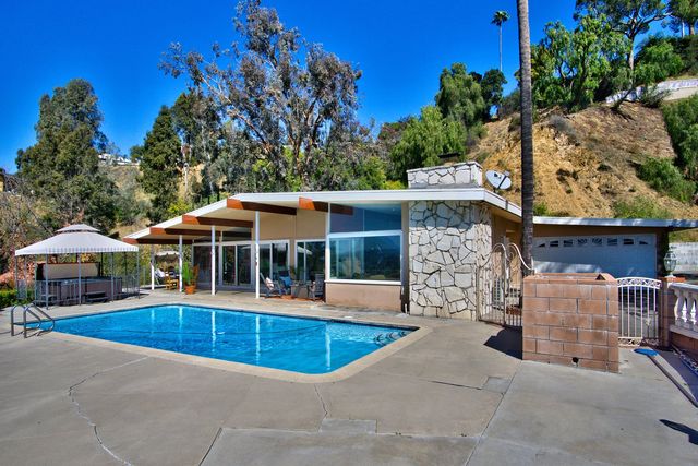 Backyard pool and mid-century home on a hillside