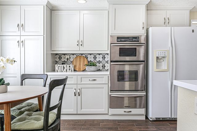 Kitchen with white cabinets and double ovens