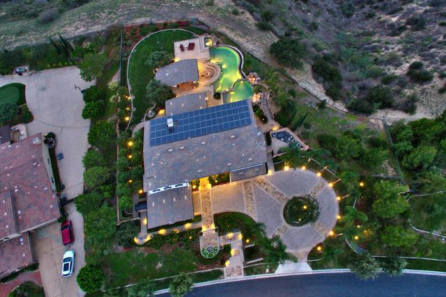 Aerial view of a home with solar panels and driveway