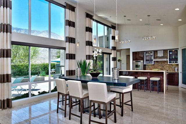Dining area with tall windows and striped drapes