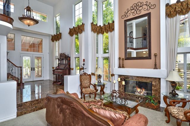 Two-story living room with fireplace and tall windows