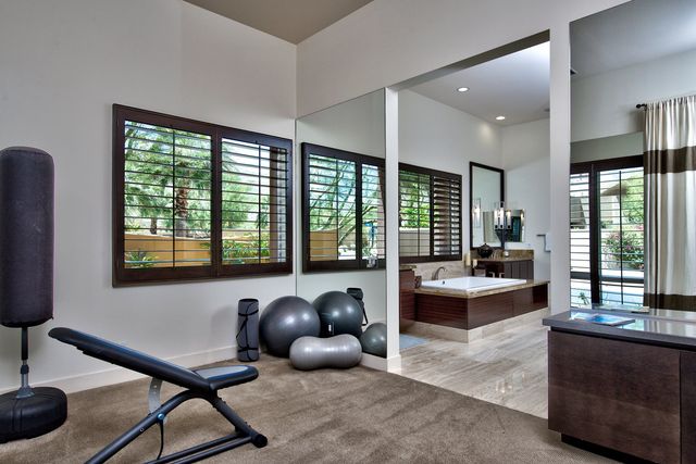 Home gym with exercise equipment and mirrors