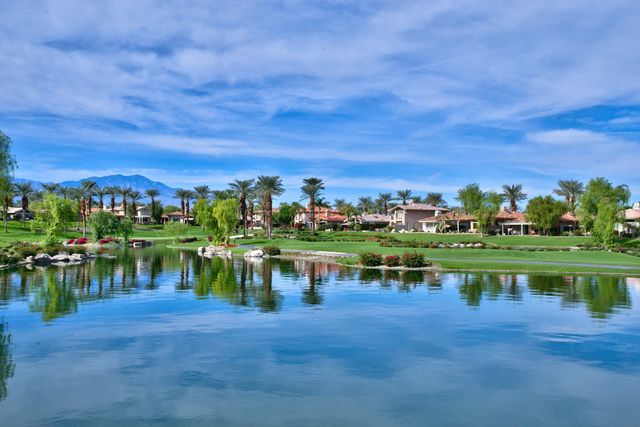 Lake and fairway view with palm trees under blue sky