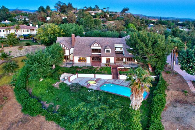 Aerial view of a home with pool and mature trees