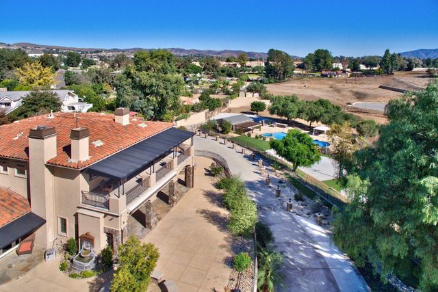 Aerial view of a hillside home with terracotta roof