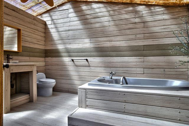 Bathroom with wood-paneled walls and tub