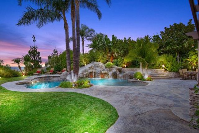 Backyard pool with waterfall and lawn