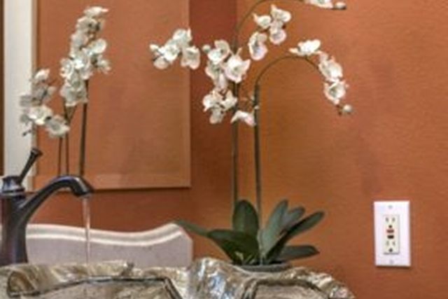 Orchid and glass vessel sink detail
