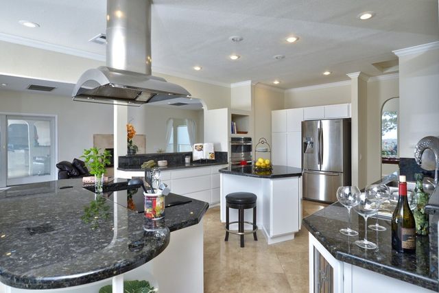 Gourmet kitchen with granite island and stainless range hood